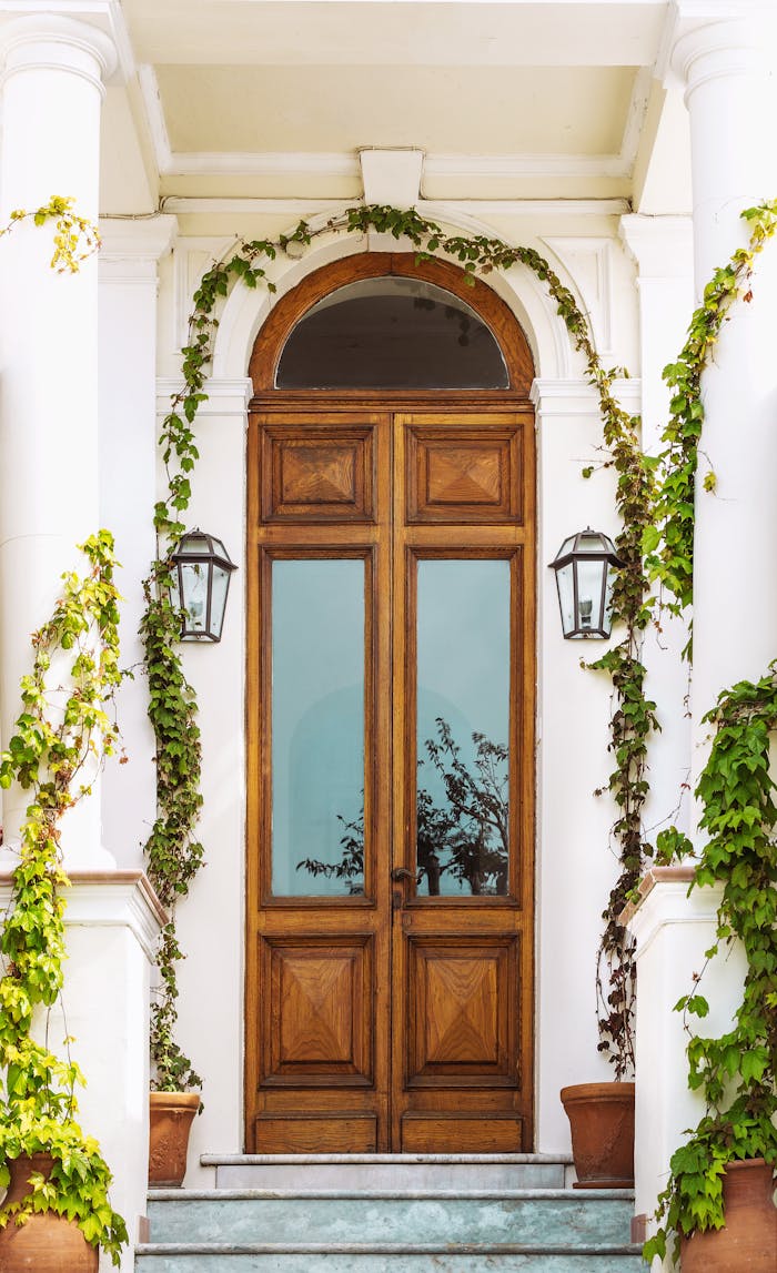 service-03 Charming wooden entrance with ivy, potted plants, and vintage lanterns in Capri, Italy.
